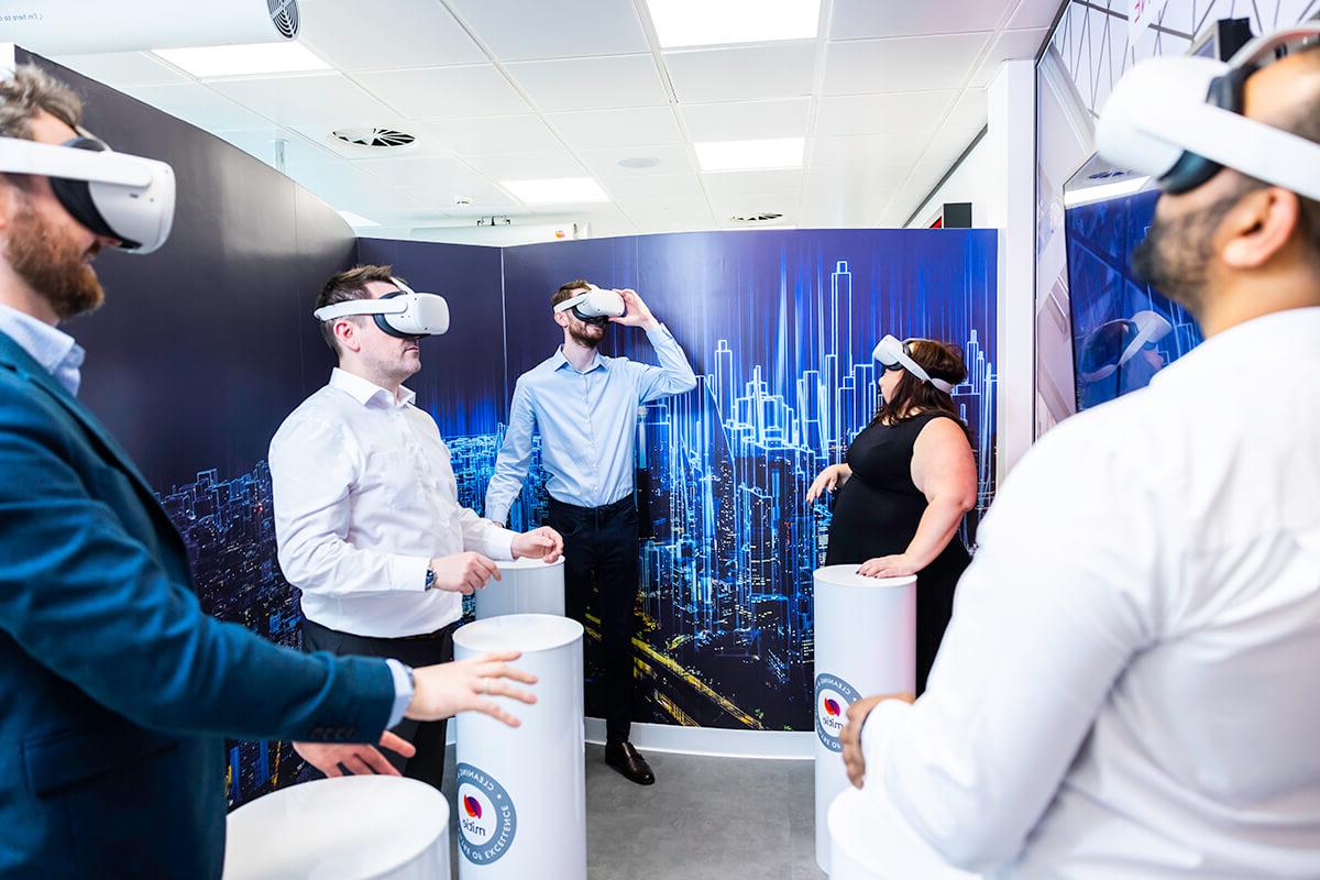 A group of people wearing white virtual reality (VR) headsets in the Mitie清洁 and Hygiene Centre of Excellence, to experience virtual cleaning environments and training